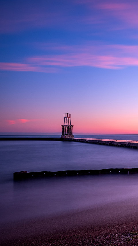 Lake Michigan water pours over walkway under morning sunrise screenshot