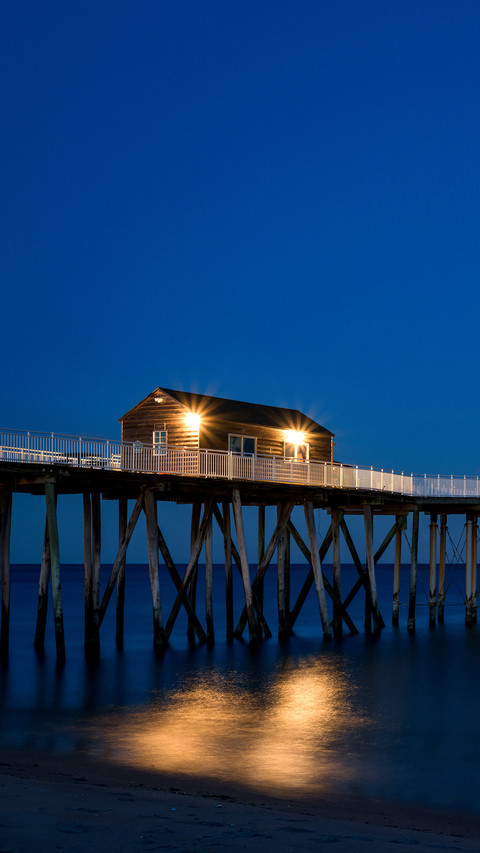 Full moon rising near a fishing pier screenshot