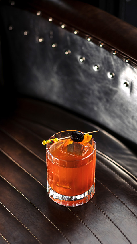 A cocktail with ice and a toothpick with olives in a glass screenshot
