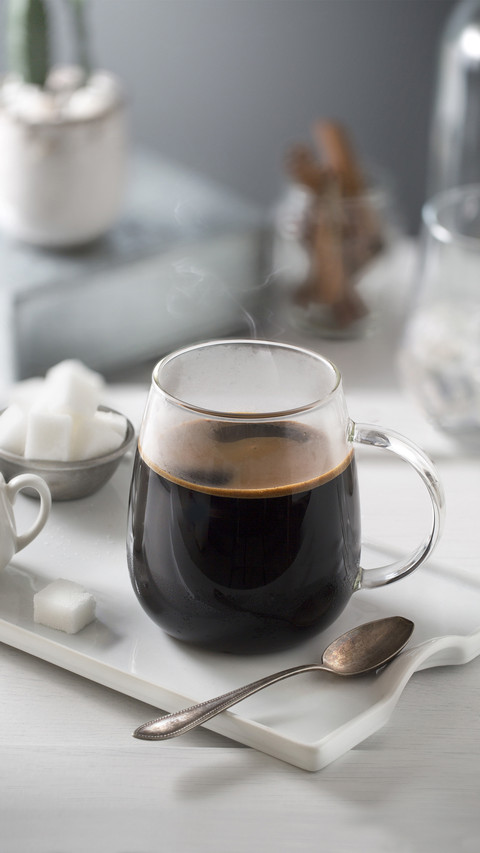 Black coffee on shallow depth of field grey background screenshot