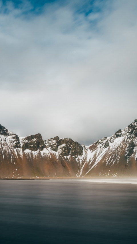 The snow-capped mountain reflects the cold sky screenshot