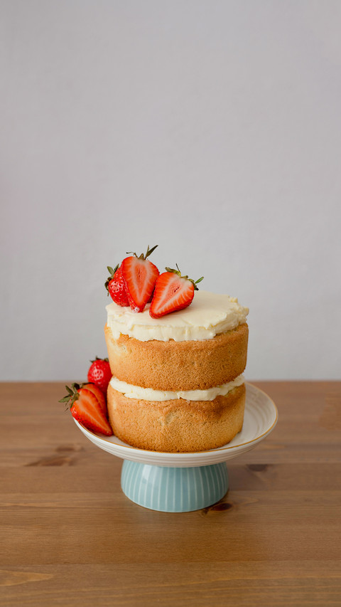 Strawberry cake on stand on wooden table screenshot