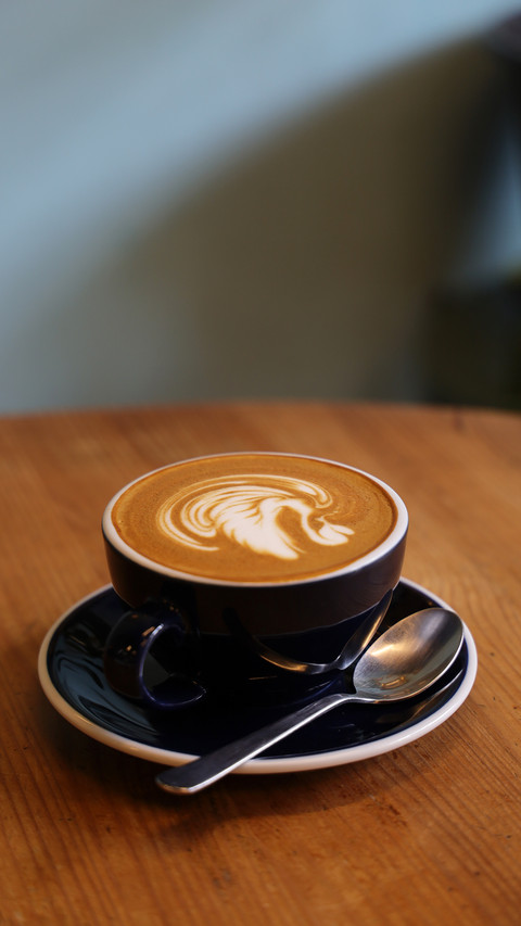Coffee latte art on the wood desk in coffee shop cafe screenshot