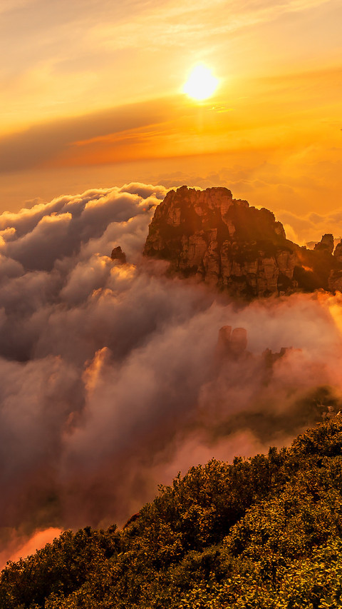 The sea of clouds and the glow of the sunset tint the screenshot