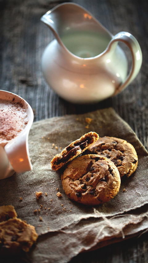 Chocolate chip cookies and cup of coffee on wooden table screenshot