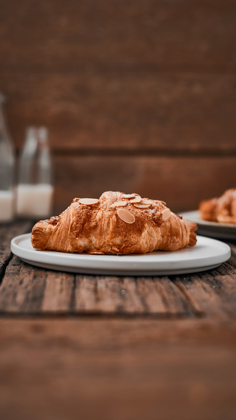 Almond croissant with custard filling on wood background screenshot