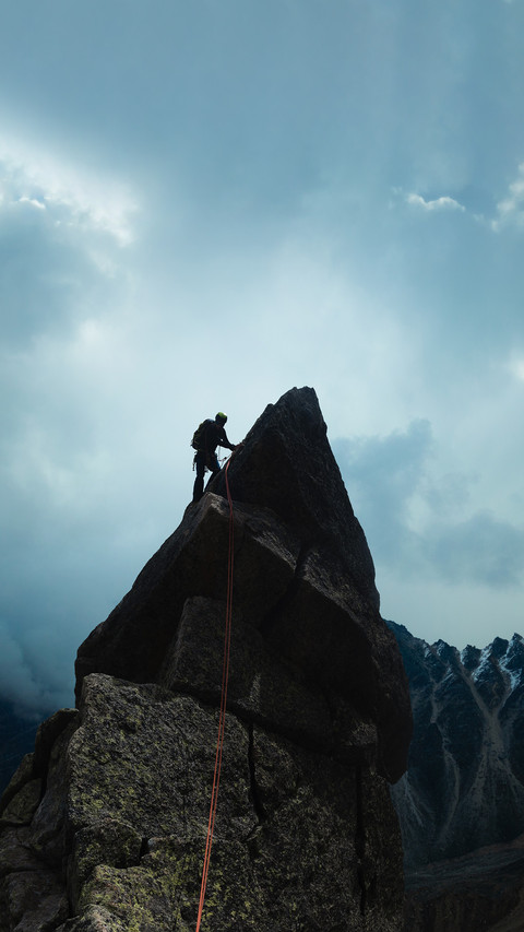 Man climber looking for adventure on top of the mountain screenshot