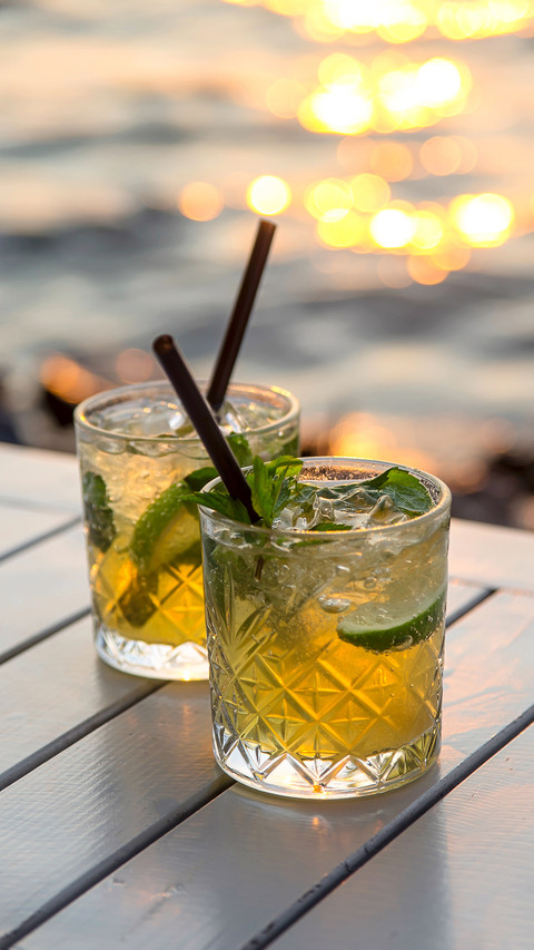 Two glasses of mojito with lime and mint on a white table screenshot