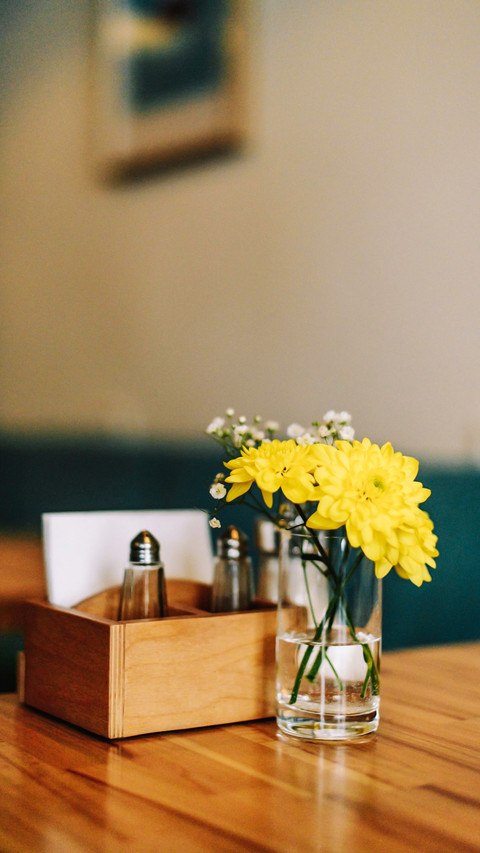 Still life flowers in a vase on a table in a coffee shop screenshot