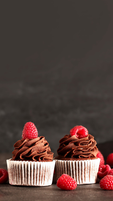 Tasty chocolate cupcakes with raspberry on dark background screenshot