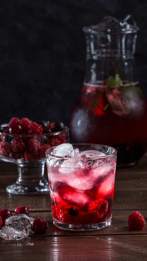Berry lemonade in a transparent glass on a dark background screenshot