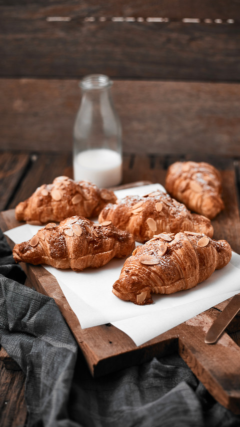 Almond croissant with custard filling on wood background screenshot