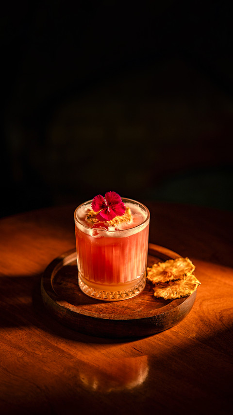 A beautifully crafted cocktail with a vibrant flower garnish screenshot
