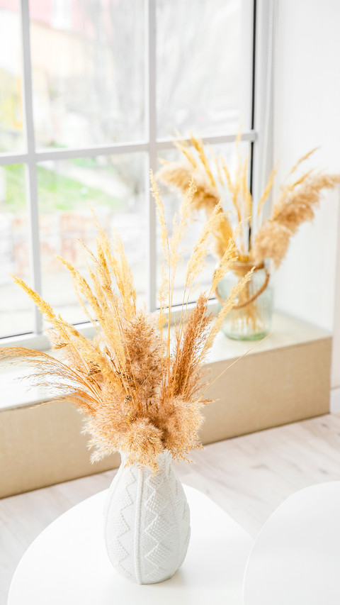 Vase with pampas grass on table in living room screenshot