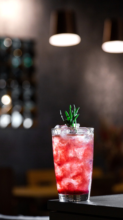 A cocktail with syrup, ice and rosemary in a glass screenshot