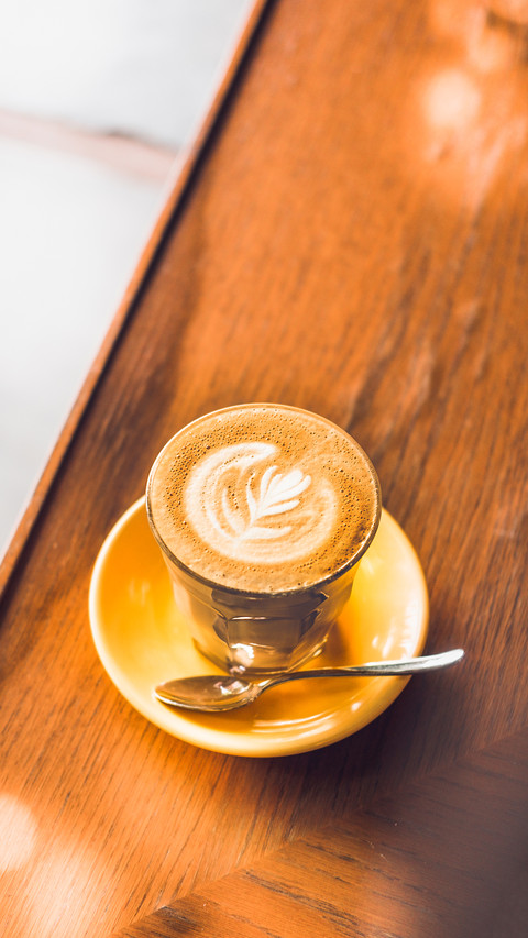 The coffee on yellow plate placed on the wooden table screenshot