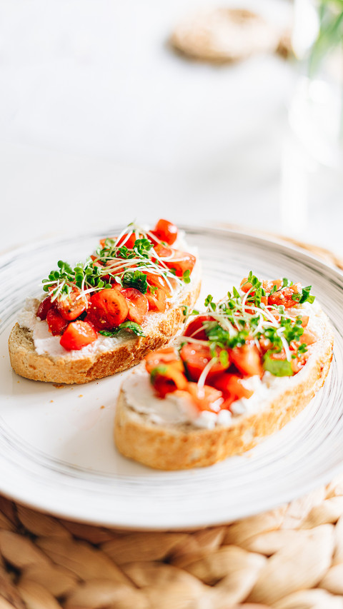 Tomato bread with ricotta and micro grass on white plate screenshot