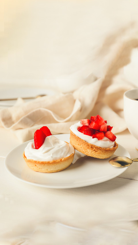 Plate with tasty tartlets and cup of coffee on table screenshot
