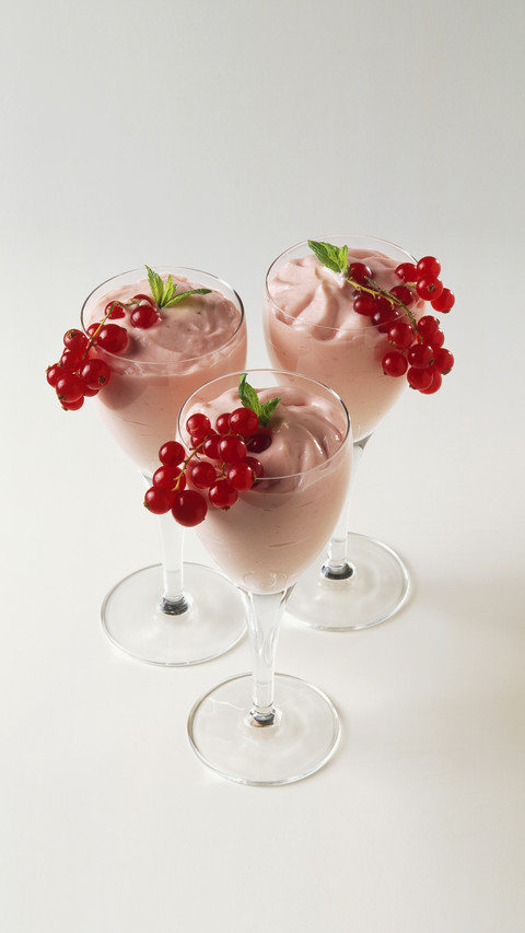 Three redcurrant cream desserts served in stemmed glasses screenshot