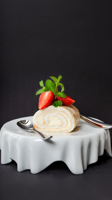 Pavlova roll dessert with strawberry on white unusual plate screenshot