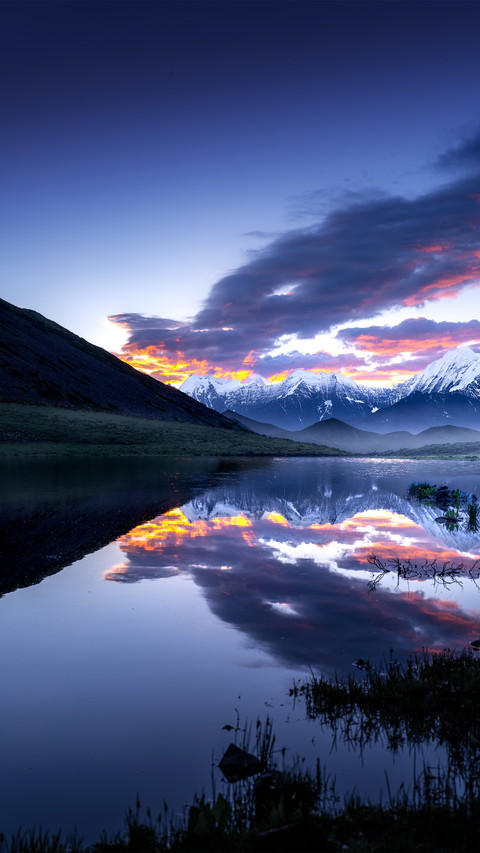 The snowcapped mountains reflect the morning glow screenshot