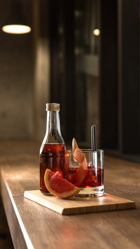 Bottle and glass of red fresh alcoholic cocktail with ice screenshot