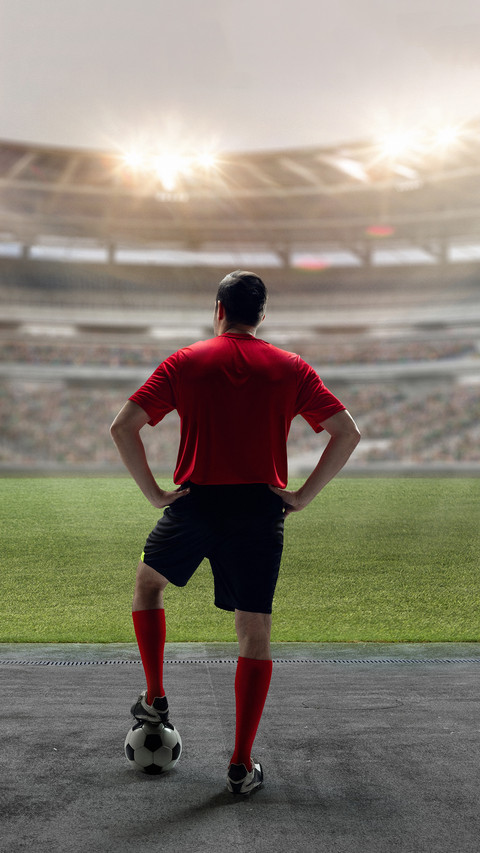 Football player standing with ball screenshot