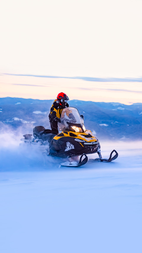 A man is riding snowmobile in mountains screenshot