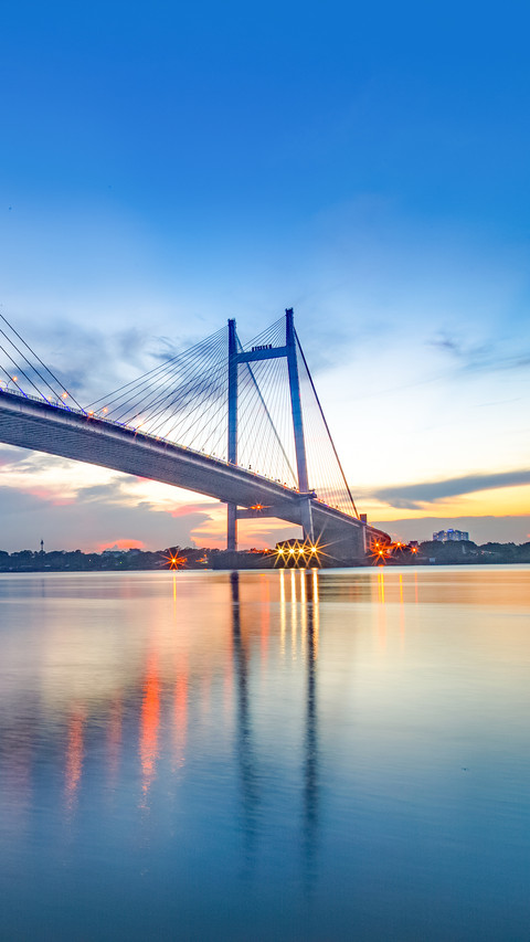 A  bridge on river Hooghly at dusk with city light screenshot