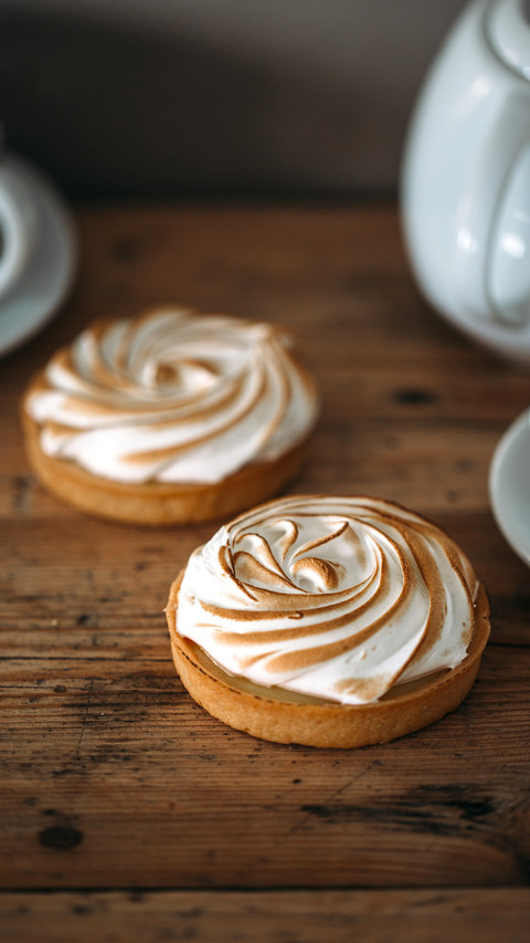 Tartlet with lemon cream and meringue on wooden background screenshot