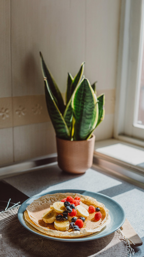 A vertical shot of thin pancakes with berries screenshot
