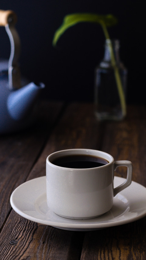 White cup with blue pot on a rustic wooden table screenshot