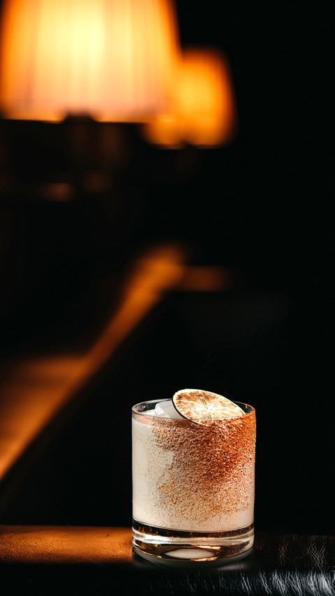 Vertical view of lime cocktail on a black leather sofa screenshot