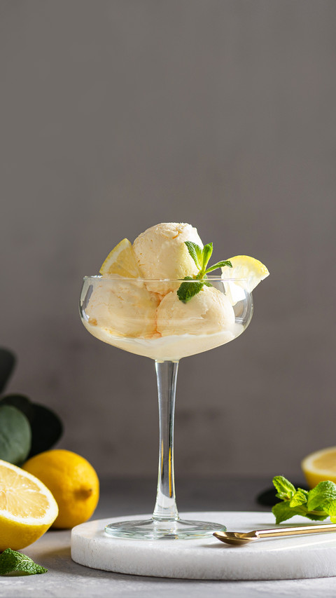Lemon ice cream scoops with fresh citrus and mint in a glass screenshot