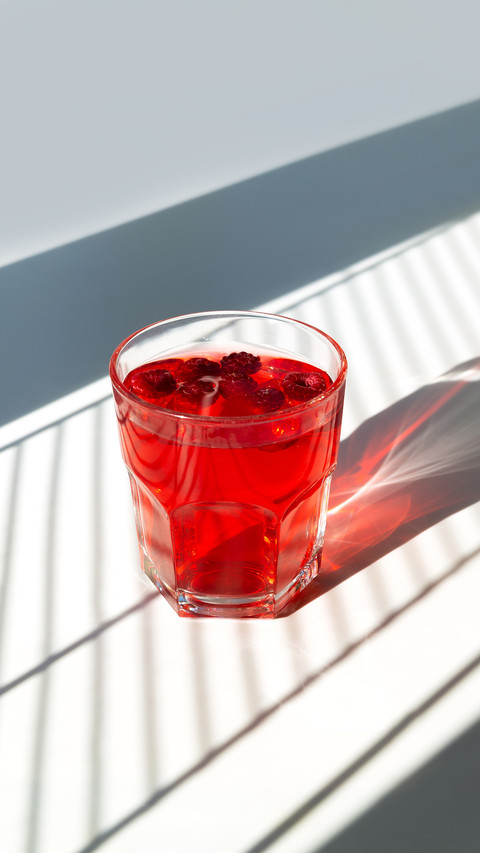 Red cocktail with raspberries in a glass screenshot