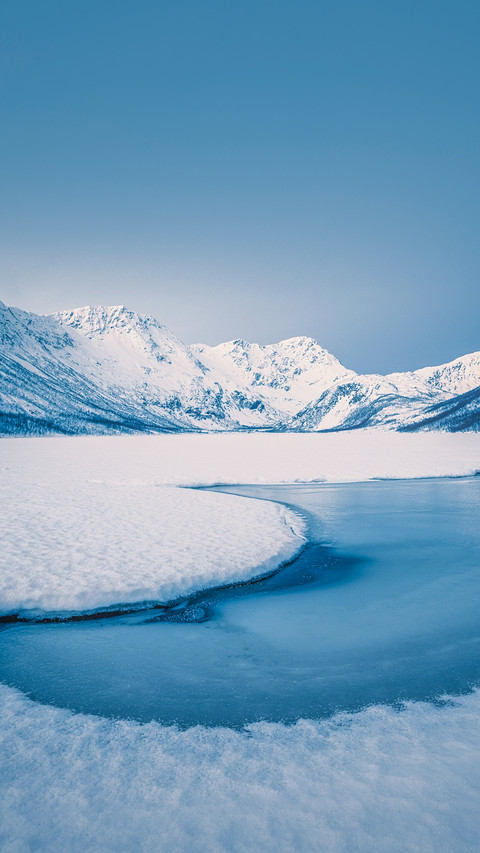 Snowy peaks, blue skies,  and frozen lakes screenshot