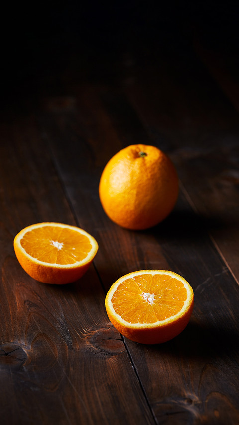 Navel Oranges on a dark brown textured wooden surface screenshot