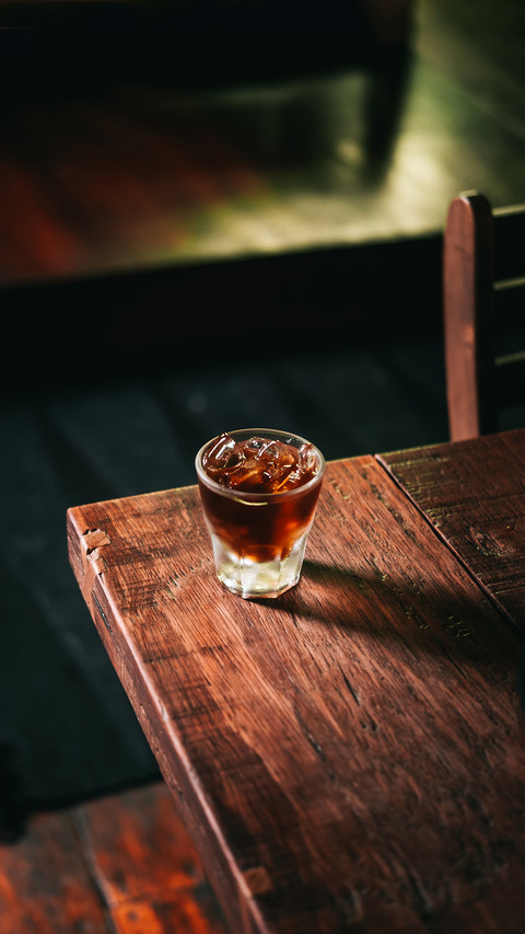 Cold brew coffee with ice cubes on the wooden table screenshot