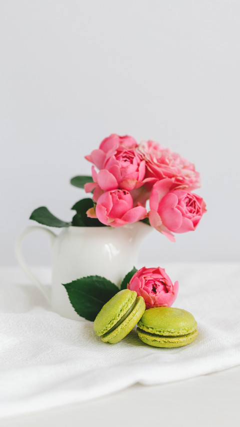 Two tasty French macarons and a jar with beautiful roses screenshot