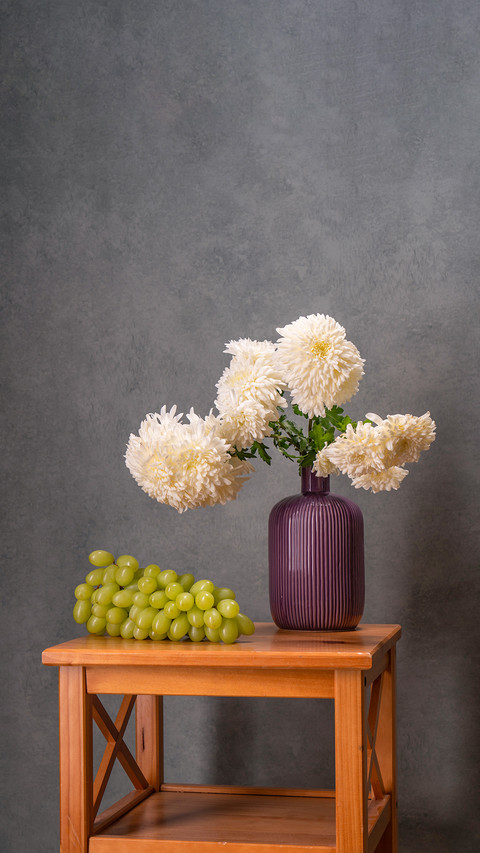 Bouquet of white dahlias in a lilac vase on gray background screenshot