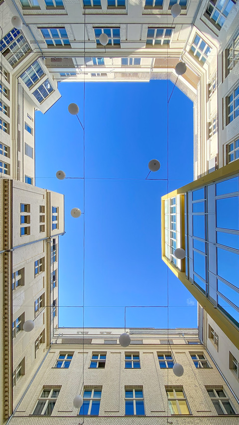 courtyard of apartment block against blue sky screenshot