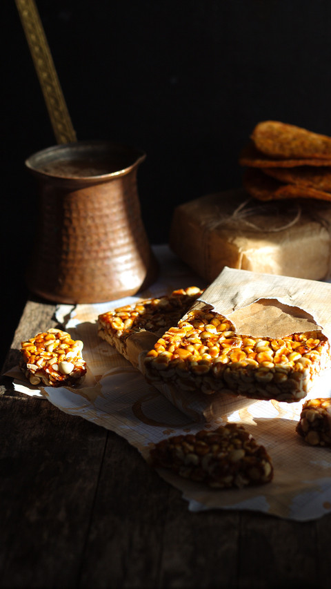 Peanut brittle on a wooden table in a rustic dark background screenshot