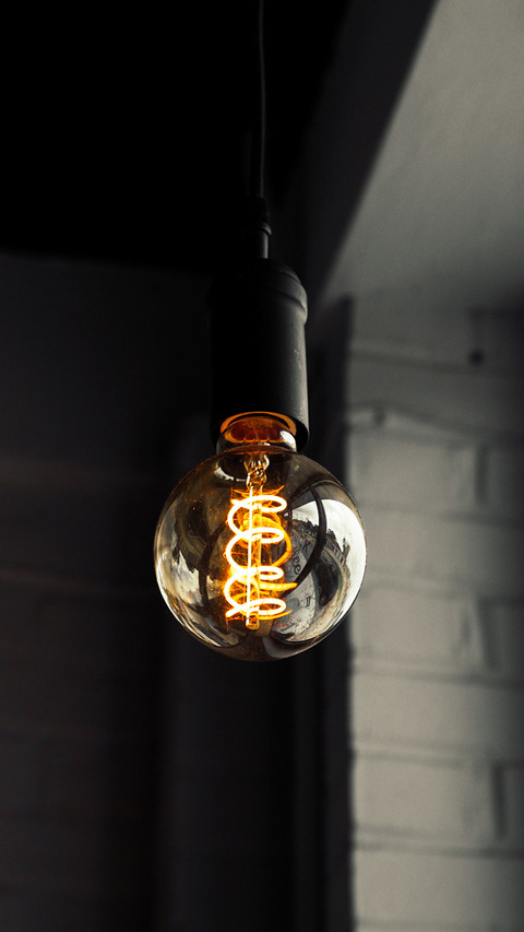 Industrial lightbulb with bright glow and dark background screenshot