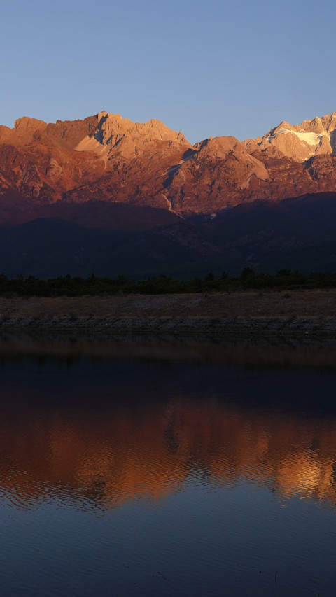 Jade Dragon Snow Mountain bathed in sunlight, turning golden screenshot