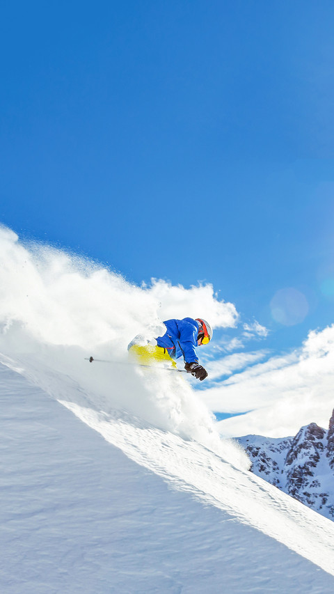 Skier running downhill on piste in Alpine landscape screenshot