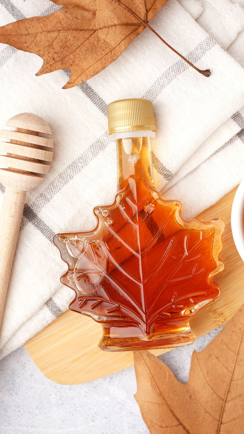 Bottle of tasty maple syrup on table screenshot