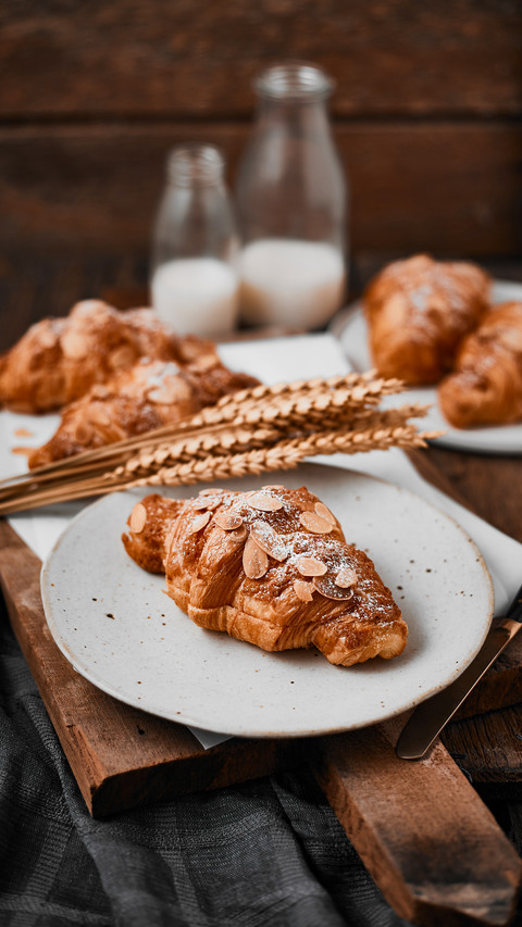 Almond croissant with custard filling on wood background screenshot