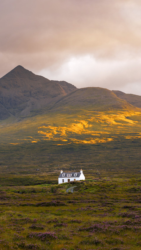Traditional Scottish cottage with Cuillin mountain peaks screenshot