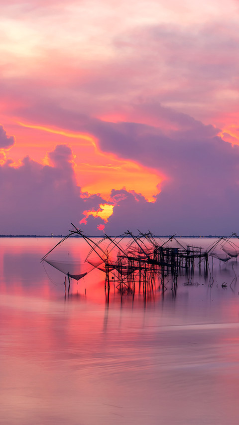 Local fishing nets in a lake with fisherman in sunrise screenshot