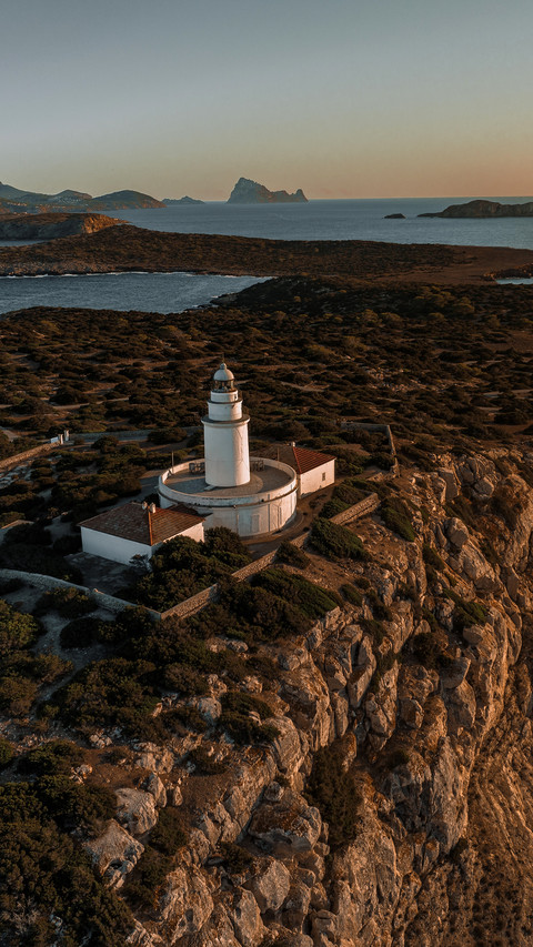 Lighthouse at sunset on cliff overlooking Mediterranean screenshot